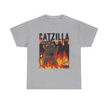 Graues T-Shirt mit Monsterkatzenmotiv: Eine übergroße Comic-Katze mit flammenden Augen steht mitten im Inferno. Um sie herum: brennende Stadt, Flammen, Chaos. Darüber der Schriftzug „CATZILLA“ – ein Mix aus Zerstörung und Niedlichkeit.
